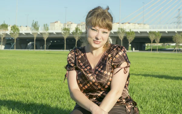 Толстая женщина сидит на зеленой траве — стоковое фото