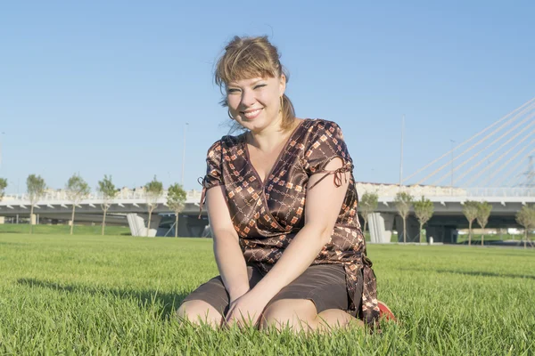 Mujer gorda sentada en la hierba verde — Foto de Stock