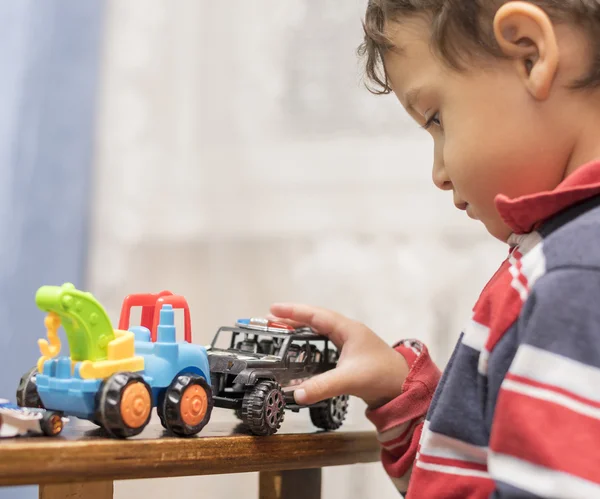 Menino brincando com carros de brinquedo — Fotografia de Stock