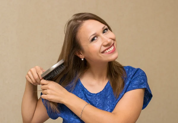 Woman combing  hair — Stock Photo, Image