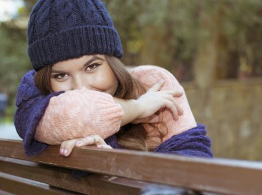 sonbaharda bir bankta oturan esmer kız