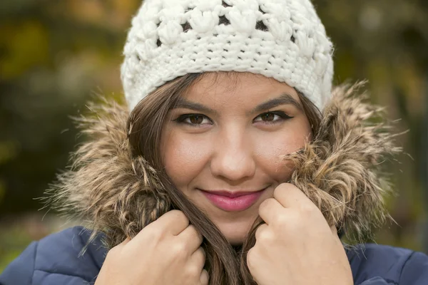 Menina morena em um chapéu de malha em um parque no outono — Fotografia de Stock