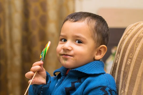 Little boy eats candy — Stock Photo, Image