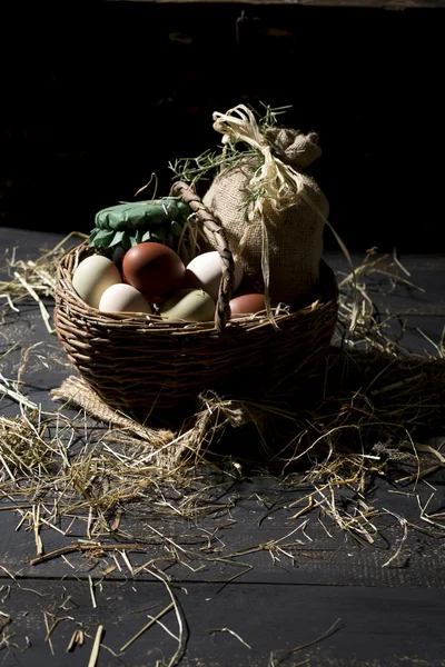 Huevos de Pascua en una canasta con paja —  Fotos de Stock