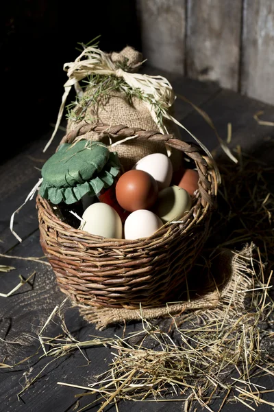 Huevos de Pascua en una canasta con paja —  Fotos de Stock