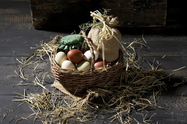 Huevos de Pascua en una canasta con paja —  Fotos de Stock