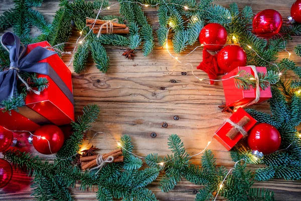 Noel ağacının ahşap arka plan dallarında Noel oyuncakları ve yılbaşı süslerini ışıklarla süslüyor.