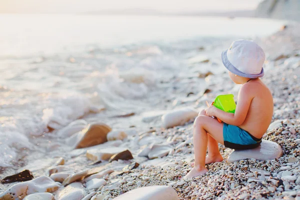 Enfant sur un rocher sur la plage — Photo