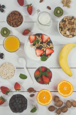 Çilekli yoğurt, meyve, kaşık, kaşık, kâse sağlıklı. Tahta, karamsar bir portre formatında yoğurt yiyor.