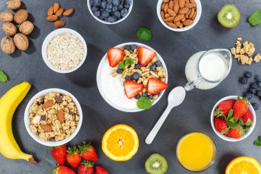 Çilekli yoğurt, meyveli kahvaltı, kaşık kâsesi sağlıklı, tahtada yoğurt yiyor.