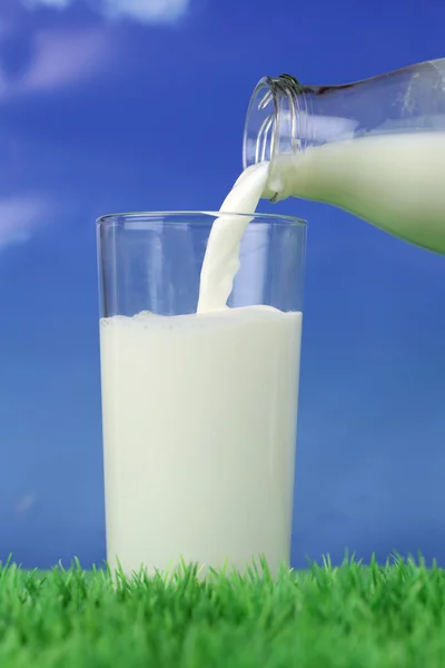 Milk pouring into a glass — Stock Photo, Image