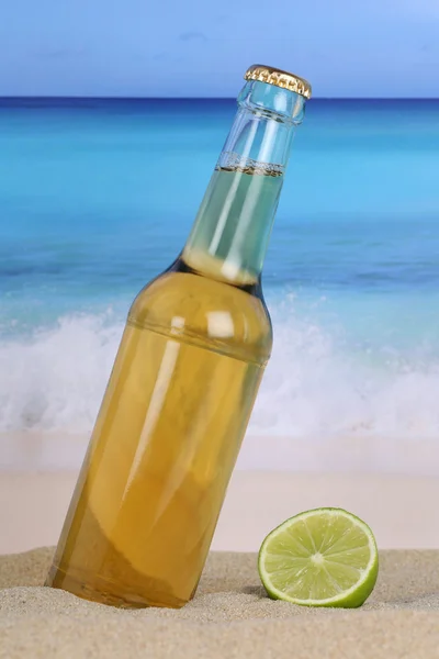 Bier in de fles op het strand en zand — Stockfoto