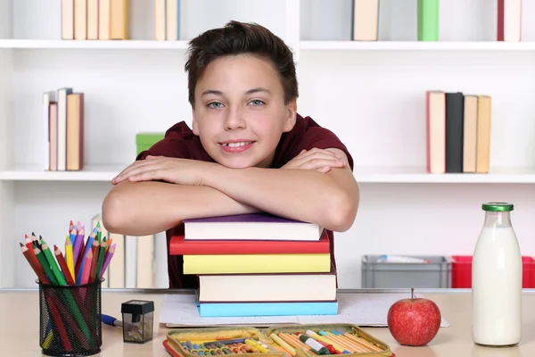 Niño en una pila de libros en la escuela — Foto de Stock