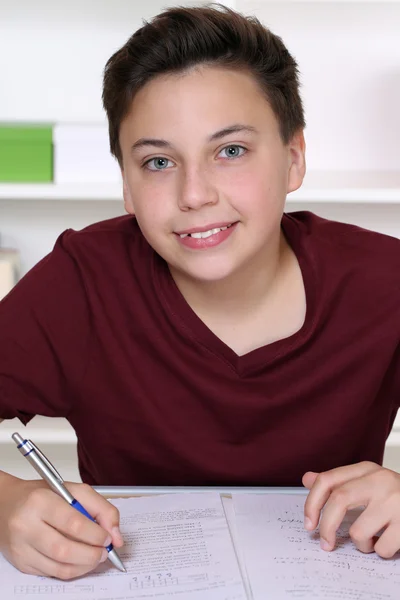 Jonge student schriftelijk zijn werkboek op school — Stockfoto