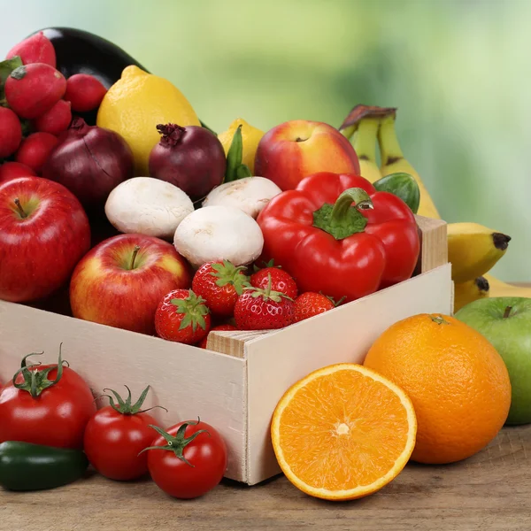 Frutas y verduras como naranjas, manzanas y tomates en caja — Foto de Stock