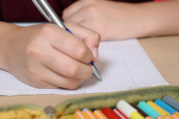 Student writing in his exercise book at school — Stock Photo, Image