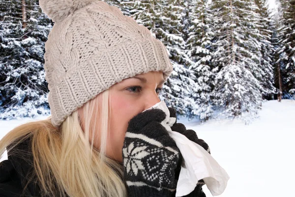 Jeune femme avec un rhume et le virus de la grippe éternuant dans un tissu — Photo