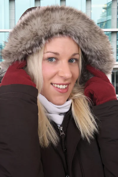 Lächelnde Frau im Winter mit warmer Kleidung draußen in der Stadt — Stockfoto