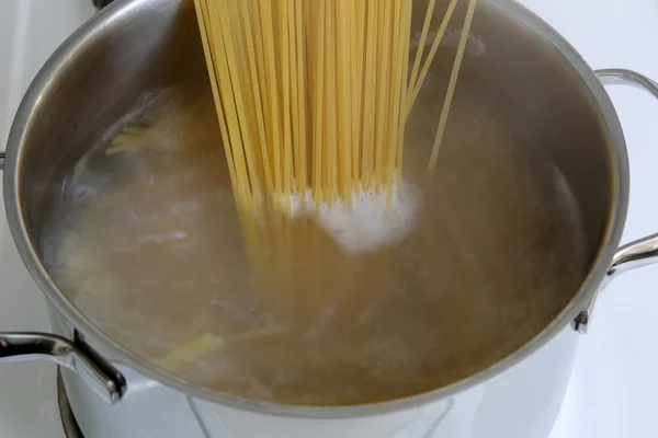 Preparing spaghetti pasta meal: cooking noodles in water — Stock Photo, Image