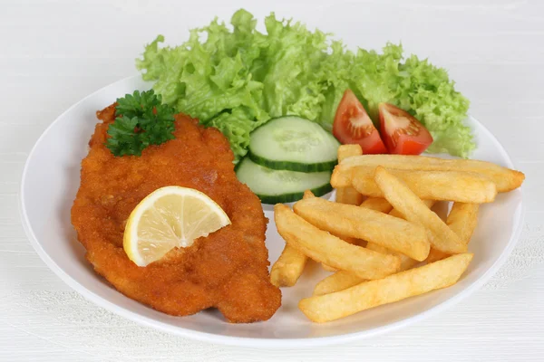 Schnitzel maaltijd met Franse frietjes, salade en citroen — Stockfoto