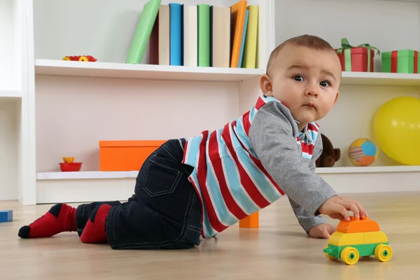 Bebê bonito brincando com carro de brinquedo — Fotografia de Stock