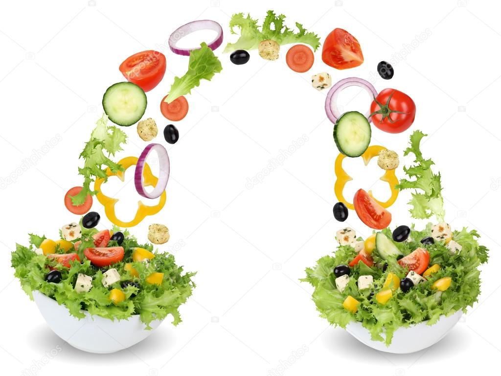 Flying salad ingredients in bowl with tomatoes, onion, olives an