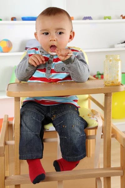 Дитина їсть дитяче харчування з ложкою — стокове фото
