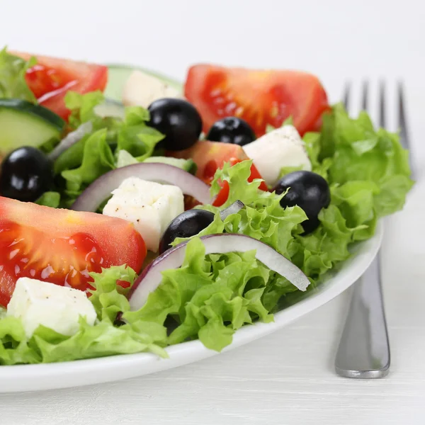 Comer ensalada griega en un tazón con tomates, queso Feta, aceitunas y —  Fotos de Stock