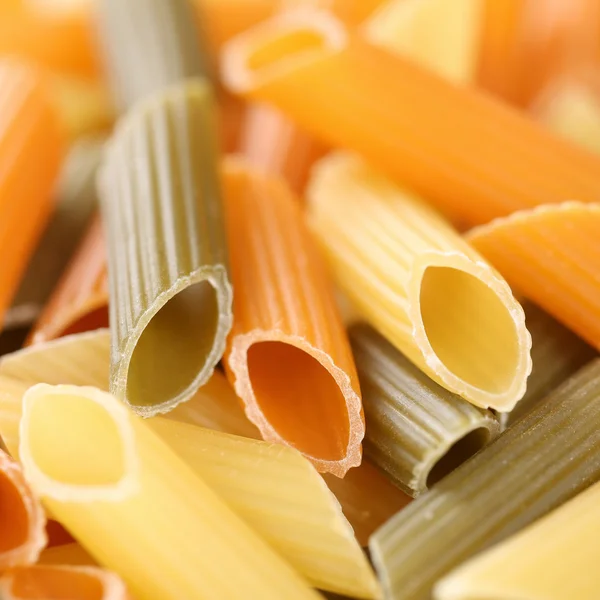 Colorful raw Penne Rigatoni noodles pasta with copyspace — Stock Photo, Image