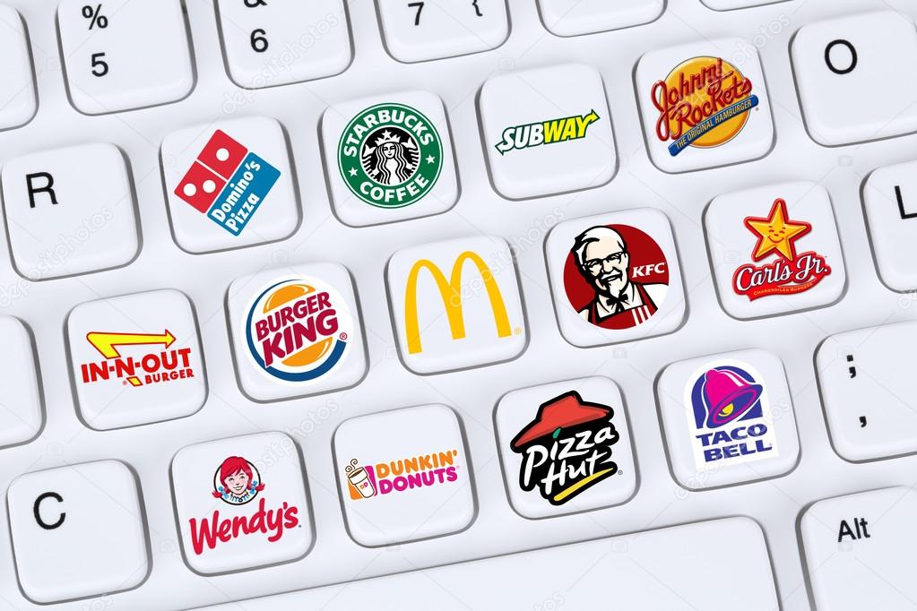 Berlin, Germany - April 7, 2015: Collection of logos of fast food restaurants like Mc Donalds, Burger King, KFC, Starbucks, Pizza Hut on a computer keyboard.