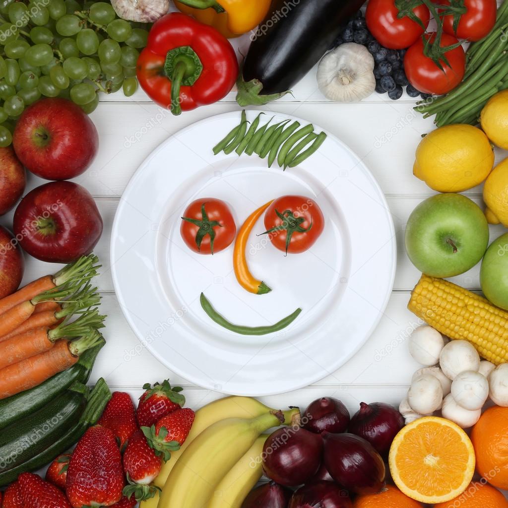 Vegetarian eating smiling face from vegetables and fruits on pla