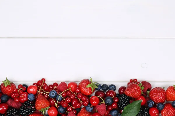 Bessen vruchten op een houten bord met aardbeien, bosbessen, che — Stockfoto