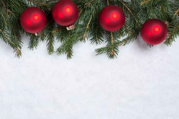 Vánoční pozadí s jedlovými větvemi, míčky a sněhem — Stock fotografie