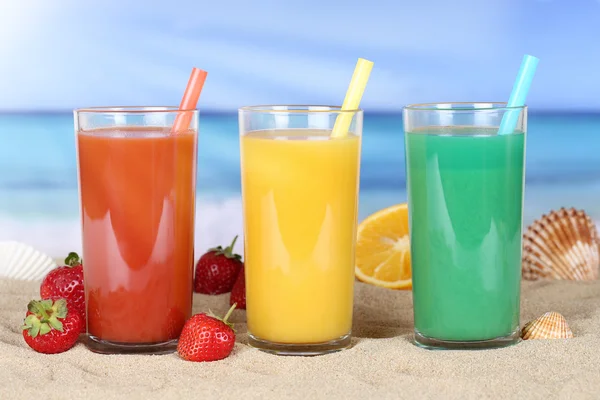 Smoothie fruit orange juice with fruits on the beach — 图库照片