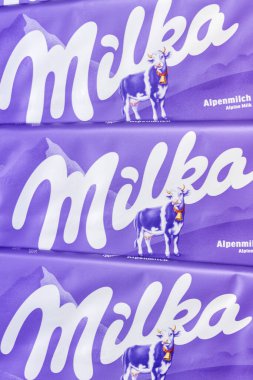 Stuttgart, Almanya - 18 Eylül 2025: Milka çikolatalı 90g bar Alp sütü yakın plan şirket logosu Stuttgart, Almanya.