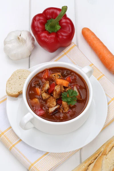 Суп из гуляша с багетом, мясом и паприкой в чашке — стоковое фото