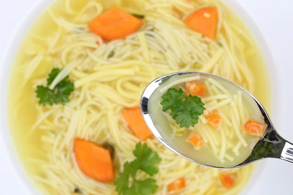 Comer sopa de fideos en un tazón con fideos y cuchara —  Fotos de Stock