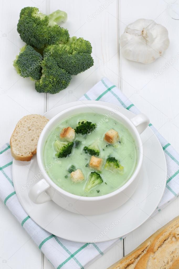 Broccoli soup in bowl with baguette