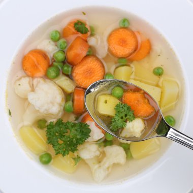 Healthy eating vegetable soup meal with vegetables on spoon from