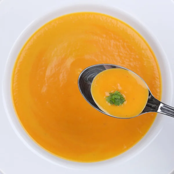 Healthy eating carrot soup with carrots on spoon from above — Stok fotoğraf