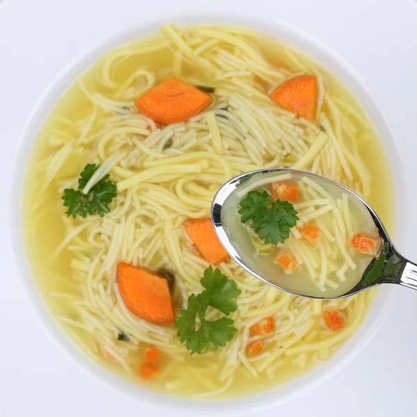 Note di alimentazione zuppa di tagliatelle in ciotola con tagliatelle e cucchiaio — Foto Stock