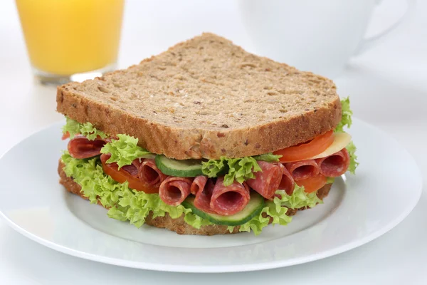 Sandwich toast brood voor het ontbijt met salami en sinaasappelsap — Stockfoto
