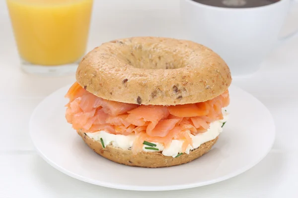Sanduíche de bagel para café da manhã com peixe de salmão, suco de laranja e — Fotografia de Stock