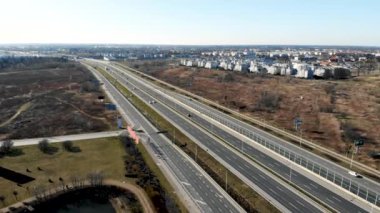 Çağdaş megalopolis 'te güneşli bir sonbahar gününde araba trafiği olan modern çoklu şeritli yolun yukarısından