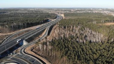 Taşradaki ağaçlık alanda araçlarla çağdaş yüksek otoyol kavşağının insansız hava aracı görüntüsü