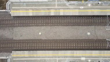 Yukarıdan aşağıya doğru, insansız hava aracı tren yolu boyunca uçuyor.