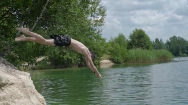 Bir genç uçurumdan balıklama atlayıp ağır çekimde suya atlıyor..