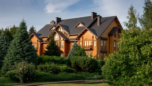 Etrafı yeşil ağaçlarla çevrili ahşap güzel bir ev.
