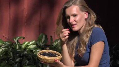 kadın yakın gülen taze Bahçe böğürtlen yiyin. 4k