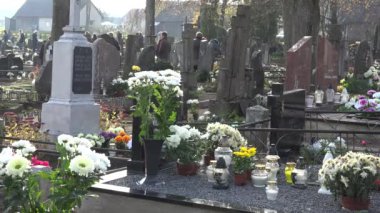 çiçekler ve mumlar mezarlığı ve insanlar ölü aile üyeleri ziyaret edin. 4k
